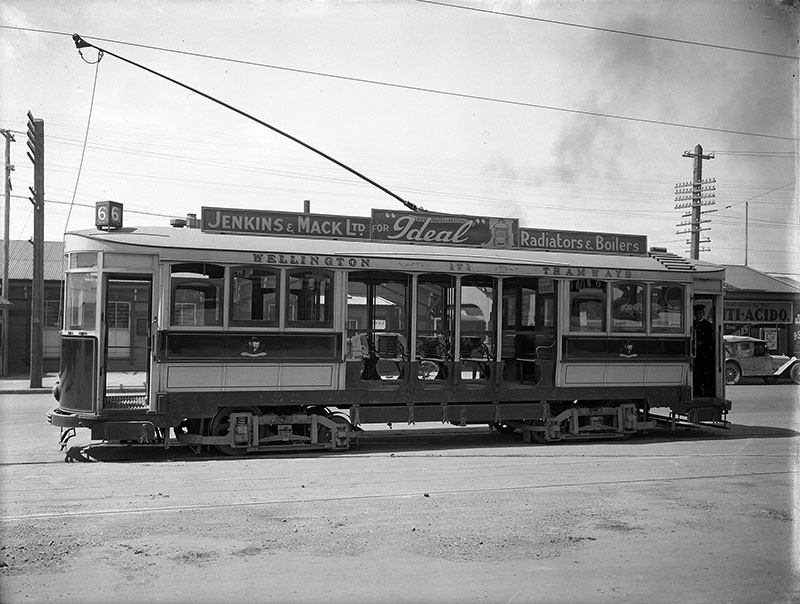 Side view of a Wellington tram. A tram conductor is inside on the right, c. 1920s.
